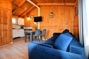 a living room with a blue couch and a table at Domki Anetta in Dąbki