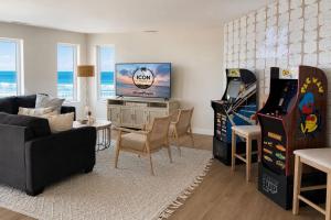 a living room with a tv and two arcade games at Icon Playce: Beachfront with 360 rooftop in Atlantic City