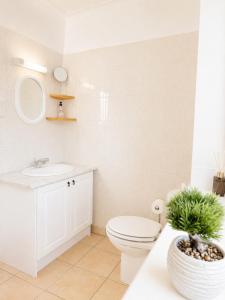 a white bathroom with a toilet and a sink at Ashwood Stays in Surbiton