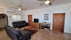 a living room with a leather couch and a tv at Casa Evita in Puerto Peñasco