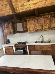 a kitchen with wooden cabinets and a sink and a stove at Hermosa cabaña de lujo MADERA in Tochimpa