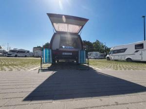 a bus parked in a parking lot with a trailer at Retro Kamper Jastarnia in Jastarnia