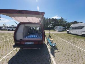a back end of a van parked in a parking lot at Retro Kamper Jastarnia in Jastarnia