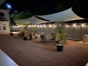 a patio with tables and chairs and a white tent at Rifugio Blu in Costinesti