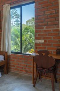 a wooden chair sitting in front of a window at Kallpa B&B in Palomino