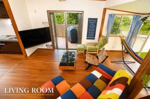 a living room with a couch and a flat screen tv at Ranked 1 in the Izu Mount Fuji from the villa in Izunokuni +23 photos