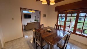 a dining room with a wooden table and chairs at Casa Verde 3 in Carhué