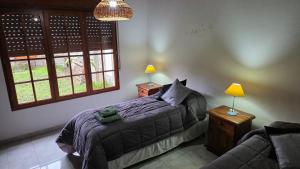 a bedroom with a bed and two lamps and a couch at Casa Verde 3 in Carhué