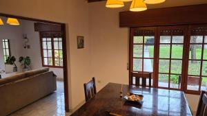 a dining room with a table and a couch at Casa Verde 3 in Carhué +3 photos