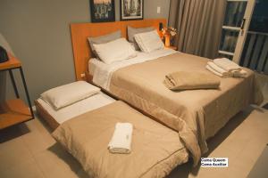 a bedroom with two beds with towels on them at Rio Branco 688 - Hospedagem Premium in Santa Maria