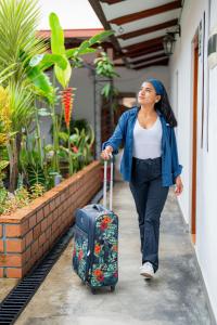 a woman walking down a sidewalk with a suitcase at Muyuterra in Moyobamba +28 photos