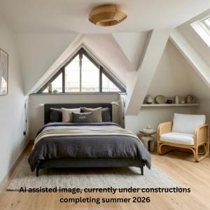 an attic bedroom with a bed and a chair at Uno By The Sea - Boutique Hotel in St Ives +13 photos