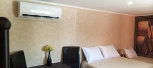 a bedroom with a bed and a tv on the wall at Retiro dos Cedros - Quarto Adega in Fogueira