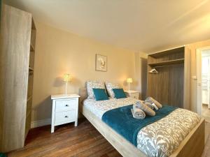a bedroom with a bed with blue pillows at Hypercentre Fontainebleau -Tout confort 2 chambres in Fontainebleau