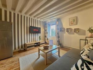 a living room with a couch and a table at Hypercentre Fontainebleau -Tout confort 2 chambres in Fontainebleau