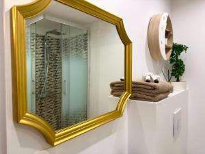 a gold mirror on a wall in a bathroom at Hypercentre Fontainebleau -Tout confort 2 chambres in Fontainebleau