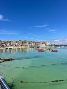 a group of boats sitting in the water at Uno By The Sea - Boutique Hotel in St Ives