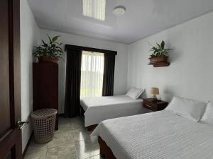 a hotel room with two beds and a window at Paradise Experience Costa Rica in Pueblo Nuevo