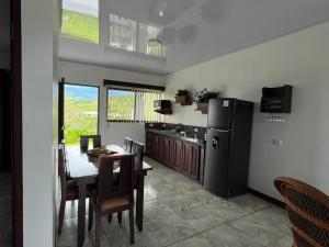 a kitchen and dining room with a table and a refrigerator at Paradise Experience Costa Rica in Pueblo Nuevo