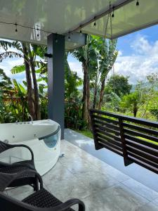 a bath tub sitting on a porch with a swing at Paradise Experience Costa Rica in Pueblo Nuevo