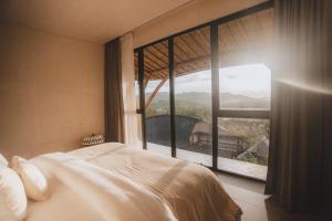 a bedroom with a bed and a large window at Mambo Lombok in Kuta Lombok +172 photos