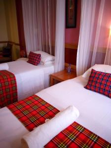 een hotelkamer met 2 bedden en handdoeken erop bij J residence Motel in Entebbe