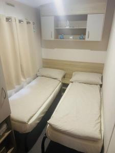 a small room with two beds in it at Casa Dana in Jaywick Sands +4 photos