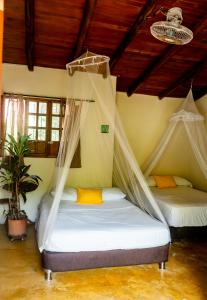 a bedroom with two beds with mosquito nets at Kallpa B&B in Palomino +71 photos