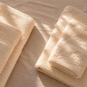 two towels sitting on top of a bed at Olivet Hotel in Vlorë
