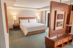 a hotel room with a bed and a mirror at GHL Hotel Capital in Bogotá