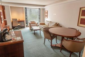 a hotel room with a table and a living room at GHL Hotel Capital in Bogotá