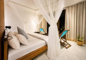 a bedroom with a bed with a canopy at CosyBe Villas in Praia do Tofo