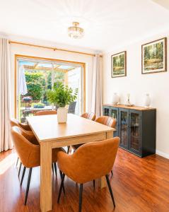 a dining room with a wooden table and chairs at Ashwood Stays in Surbiton +6 photos