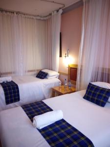 two beds in a hotel room with white and blue pillows at J residence Motel in Entebbe