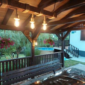 a wooden porch with a bench and lights on it at Vikendica Elena in Laktaši