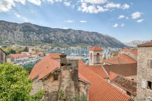 a view of a city with mountains in the background at Stunning Views & Hidden Terraces Above the Old Town in Kotor