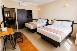 a hotel room with two beds and a desk at Hotel Palacio Maya in Mérida +21 photos