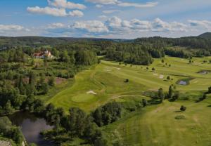 an aerial view of a golf course with a pond at Unique Villa by a beautiful lake in Omberg
