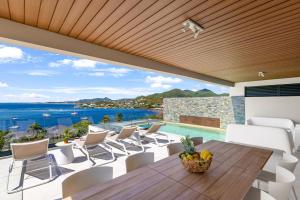 an outdoor dining room with a view of the ocean at Résidence AMARILLO Vue mer exceptionnelle face à Saint-Barthélémy in Cul de Sac