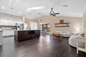 a large kitchen and living room with a ceiling fan at Elegant, 4 BDR house with a pool and BBQ in Wellington