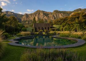 a garden with a pond in front of a house at Orgánico Hotel Boutique TEPOZTLÁN in Tepoztlán