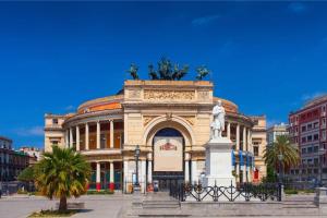 a building with a statue in front of it at Four Rooms Luxury Suite in Palermo