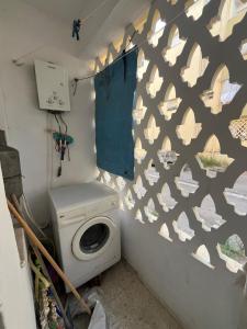 a bathroom with a washing machine and a toilet at Les Jasmin Apartment in Menzel Jemil