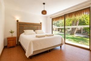 a bedroom with a bed and a large window at Cabañas Refugio El Molle in El Molle +50 photos