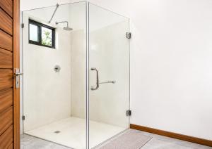 a glass shower stall in a bathroom with a window at CosyBe Villas in Praia do Tofo +80 photos