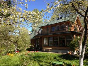 a wooden house with a bench in front of it at Vila PRI Rouzes in Palanga