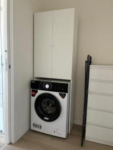 a washing machine in a room with a cabinet at La Curt by Ambroeus apartments in Inzago