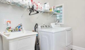 a bathroom with a sink and a washing machine at Glam Parkville Experience! in Parkville +16 photos
