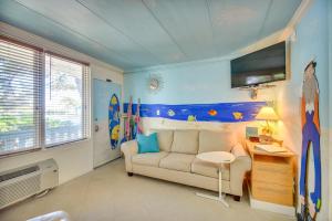 a living room with a couch and a flat screen tv at Colorful Virginia Beach Studio - Steps to Beach! in Virginia Beach