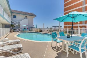 a patio with chairs and a table with an umbrella at Colorful Virginia Beach Studio - Steps to Beach! in Virginia Beach